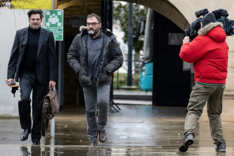 Frédéric Péchier (c), médecin anesthésiste accusé d'avoir tué 12 patients, et son avocat, Randall Schwerdorffer (g), arrivent au palais de justice de Besançon, le 8 mars 2023 ( AFP / ARNAUD FINISTRE )