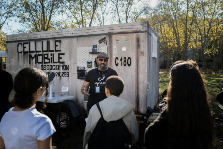Yannick Deslandes face à des jeunes devant la cellule mobile à Villeurbanne dans le Rhône le 14 octobre 2026 ( AFP / JEFF PACHOUD )