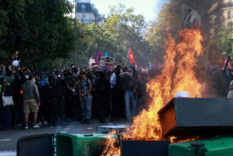 Des poubelles et du mobilier urbain incendiés lors d'une manifestation de lycéens à Paris, le 6 octobre 2026vances. ( AFP / Kenzo TRIBOUILLARD )
