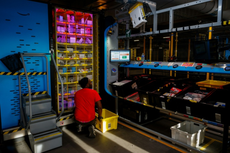 Un salarié d'Amazon s'occupe de paquets dans l'entrepôt de l'entreprise à Brétigny-sur-Orge, en Essonne, le 22 novembre 2023 ( AFP / Dimitar DILKOFF )