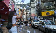 Une femme lance des tracts électoraux à Rocinha, la plus grande favela de Rio de Janeiro, le 4 octobre 2026 ( AFP / Tercio TEIXEIRA )