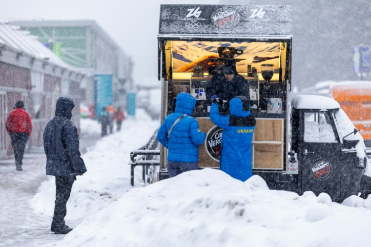 Des membres de l'équipe d'Ukraine prennent un café dans le village olympique des Jeux de Milan Cortina, le 3 février 2026 à Cortina d'Ampezzo  ( AFP / Odd ANDERSEN )