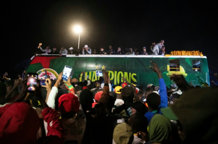 Des supporters de l'équipe de football du Sénégal accueillent le 20 janvier 2026 le bus des joueurs de retour du Maroc, après leur victoire en finale de la CAN-2025 face au Maroc   ( AFP / SEYLLOU )