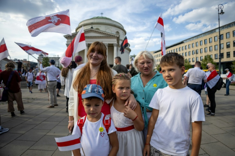 L'opposante bélarusse Antanina Kanavalava (g) sa fille Anastassia, son fils Ivan (d), sa mère Hanna et le petit Marcel (devant, g) adopté après la mort de sa mère, après une manifestation de la diaspora biélorusse à Varsovie, le 9 août 2025 en Pologne ( AFP / Wojtek RADWANSKI )