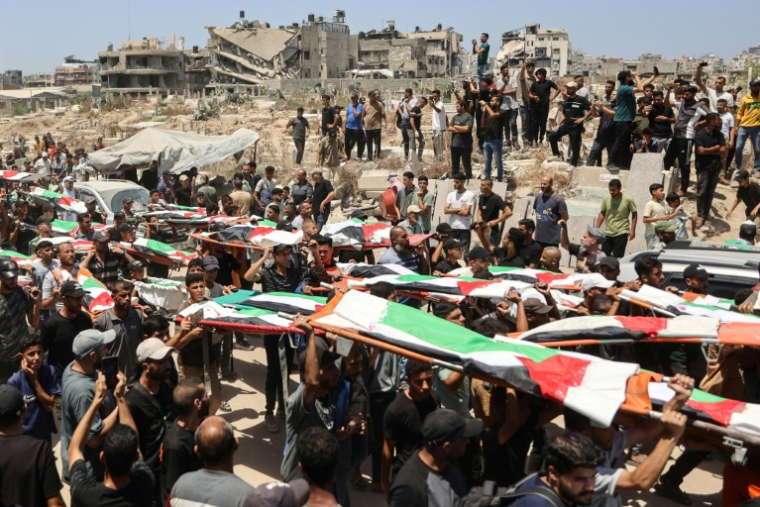 Des Palestiniens transportent des corps dans le quartier d'al-Sabra, touché par des bombardements israéliens en novembre 2023, avant leur enterrement dans la ville de Gaza, le 4 août 2026 ( AFP / Omar AL-QATTAA )