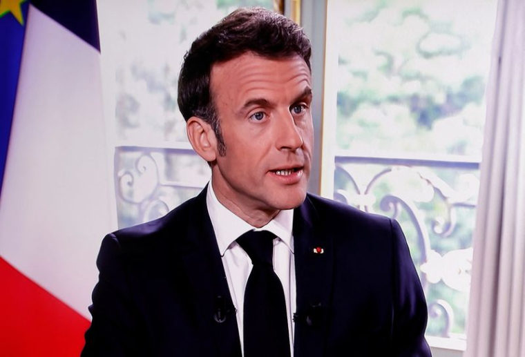 Le président français Macron est vu sur un écran alors qu'il assiste à une interview à Paris