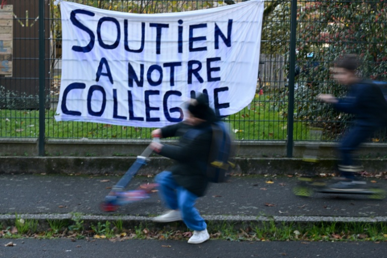 Une banderole devant l'école dont le directeur a été menacé, à Rennes, le 20 novembre 2025 ( AFP / Damien MEYER )