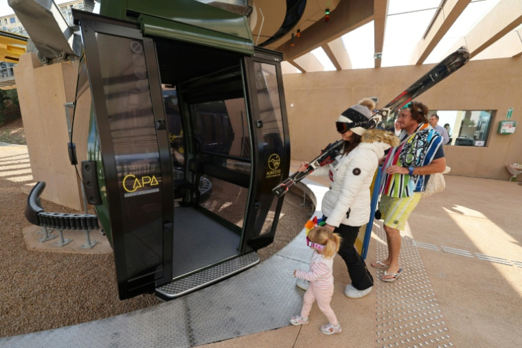 Trois personnes déguisées en vacanciers pénètrent dans la cabine du téléphérique urbain d'Ajaccio à l'occasion de son inauguration, le 18 octobre 2025 ( AFP / Pascal POCHARD-CASABIANCA )