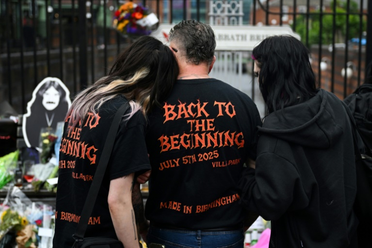 Des fans se reccueillent devant un mémorial improvisé sur le pont Black Sabbath, en hommage à l'auteur-compositeur-interprète britannique Ozzy Osbourne, au lendemain de son décès, le 23 juillet 2025 à Birmingham, dans le centre de l'Angleterre ( AFP / JUSTIN TALLIS )