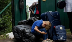 Une famille avec ses affaires attend un bus pour évacuer Mezhova, dans la région de Dnipropetrovsk, à l'est de l'Ukraine, le 17 juin 2025    ( AFP / Tetiana DZHAFAROVA )