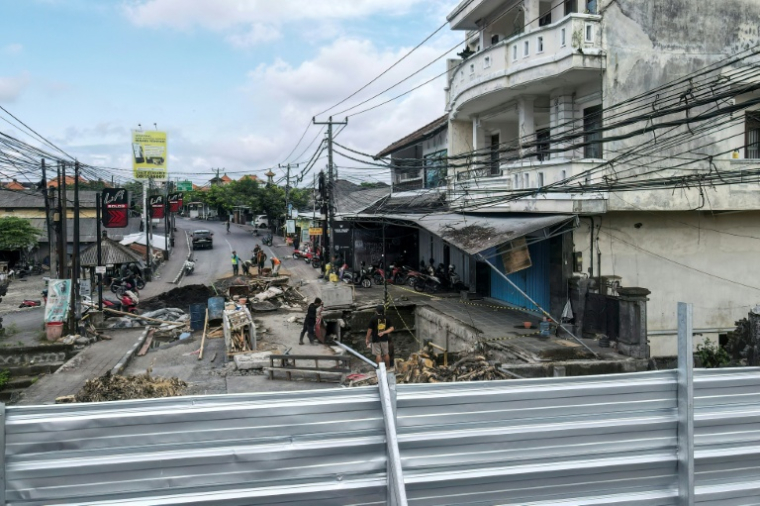 Des ouvriers réparent une zone où un gouffre s'est formé lors des récentes inondations à Badung, sur l'île touristique de Bali, le 1er octobre 2025 en Indonésie ( AFP / BAY ISMOYO )
