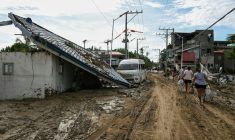 Les habitants marchent le long d'une rue couverte de boue après le passage du typhon Kalmaegi à Liloan, dans la province de Cebu aux Philippines, le 6 novembre 2025 ( AFP / Jam STA ROSA )