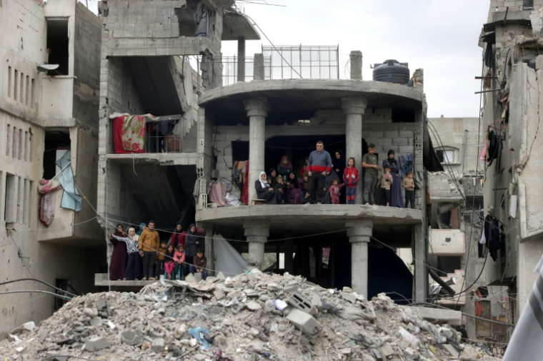 Des personnes regardent des secouristes palestiniens tenter d'extraire des victimes des décombres après une frappe israélienne sur la maison d'une famille à Jabalia, dans le nord de la bande de Gaza, le 13 avril 2025 ( AFP / BASHAR TALEB )