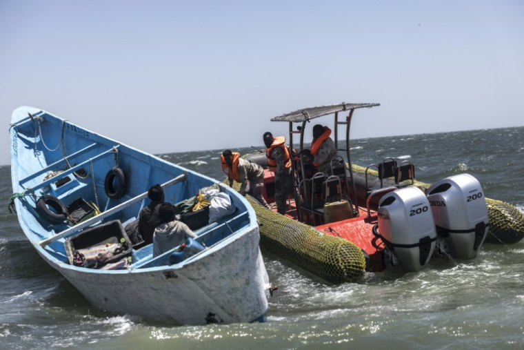Des garde-côtes mauritaniens montent à bord d'une pirogue de pêche pour vérifier les documents et les permis de pêche lors d'une patrouille au large de Nouadhibou (Mauritanie), le 23 avril 2026 ( AFP / PATRICK MEINHARDT )