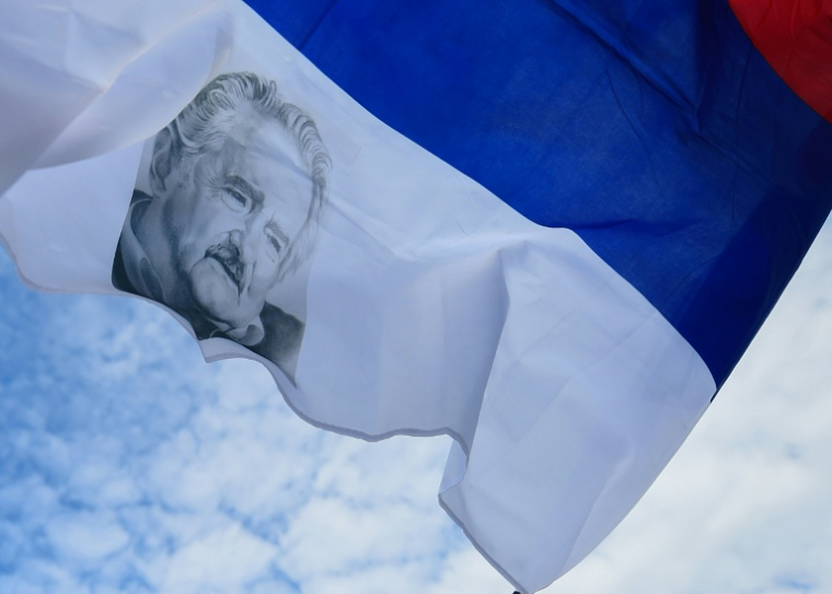 Un drapeau de la coalition Frente Amplio avec le visage de l'ancien président uruguayen Jose "Pepe" Mujica, photographié devant le Palais législatif à Montevideo, le 14 mai 2025, au lendemain de sa mort ( AFP / DANTE FERNANDEZ )