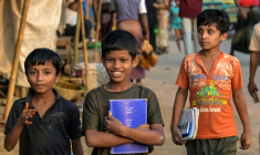 Des enfants réfugiés rohingyas portent leurs manuels scolaires au camp de réfugiés de Kutupalong, le 17 décembre 2025 à Ukhia, au Bangladesh ( AFP / Munir UZ ZAMAN )