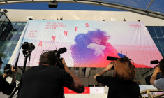 Des employés installent l'affiche officielle du 78e Festival de Cannes sur la façade du Palais des Festivals à Cannes, dans le sud-est de la France, le 11 mai 2025 ( AFP / Valery HACHE )