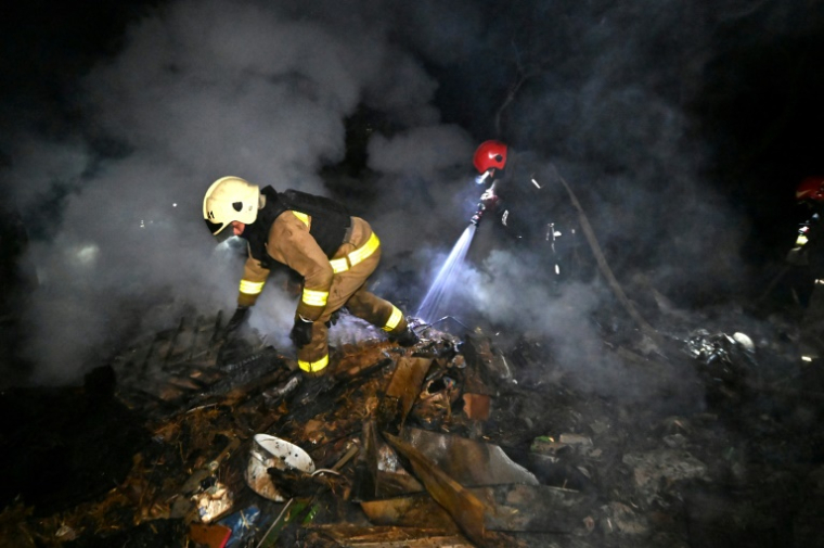 Des secouristes ukrainiens éteignent un incendie dans une maison après une attaque de drones à Kharkiv le 3 mai 2025 ( AFP / SERGEY BOBOK )