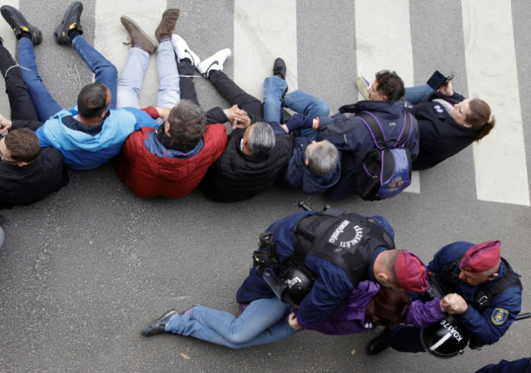 La police hongroise déloge un manifestant bloquant l'entrée du Parlement, le 14 avril 2025 à Budapest ( AFP / Peter Kohalmi )