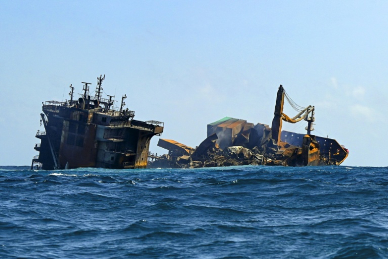 Le porte-conteneurs MV X-Press Pearl, immatriculé à Singapour et transportant des centaines de conteneurs de produits chimiques et de granulés de plastique, lors de son remorquage au large des côtes de Colombo en juin 2021 ( AFP / ISHARA S. KODIKARA )