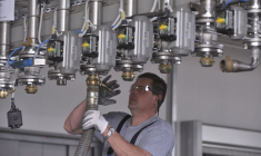 Un ouvrier répare un tuyau sur une sous-station pour peinture liquide dans l'usine Helios à Kolicevo