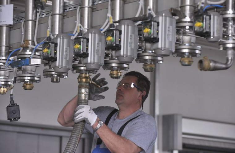 Un ouvrier répare un tuyau sur une sous-station pour peinture liquide dans l'usine Helios à Kolicevo