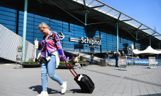 Une femme avec une valise passe par l'aéroport de Schiphol à Amsterdam, aux Pays-Bas