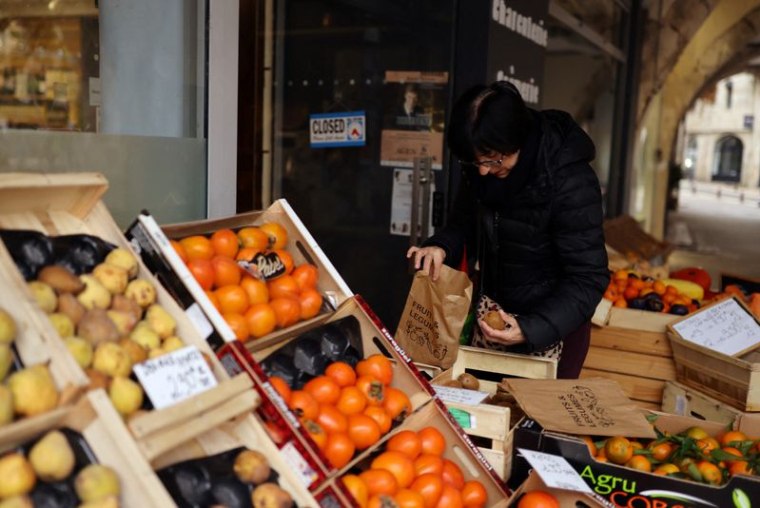 Une femme achète des fruits et légumes dans un magasin à Agen, en France
