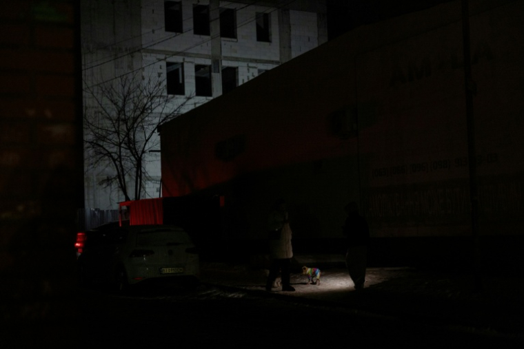 Des habitants dans l'obscurité à Vyshgorod, près de Kiev, le 30 décembre 2025 ( AFP / Tetiana DZHAFAROVA )