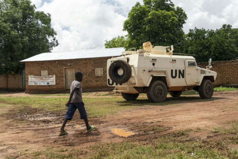 Un enfant passe devant un blindé de la Minusca à Maloum, en Centrafrique, le 24 juillet 2025 ( AFP / Mariam KONE )