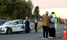 La police et des habitants près de l'endroit où un homme en cavale depuis près de quatre ans avec ses trois enfants a été abattu dans le nord de la Nouvelle-Zélande, le 8 septembre 2025  ( AFP / DJ MILLS )