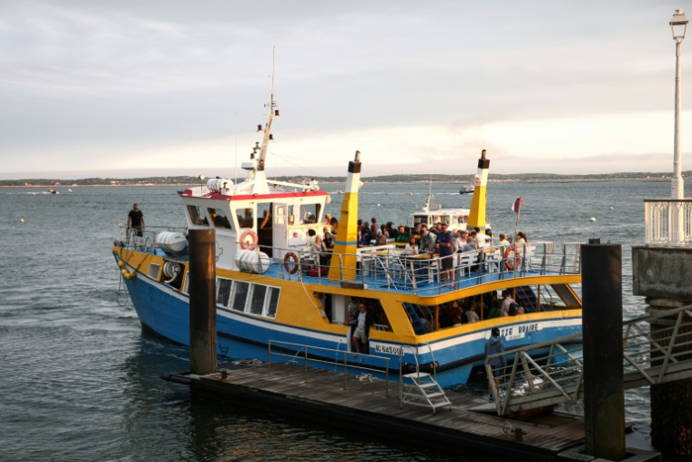 Un bateau évacuant des touristes et habitants de Lège-Cap-Ferret accoste à Arcachon, en Gironde, le 24 juillet 2026 ( AFP / ROMAIN PERROCHEAU )
