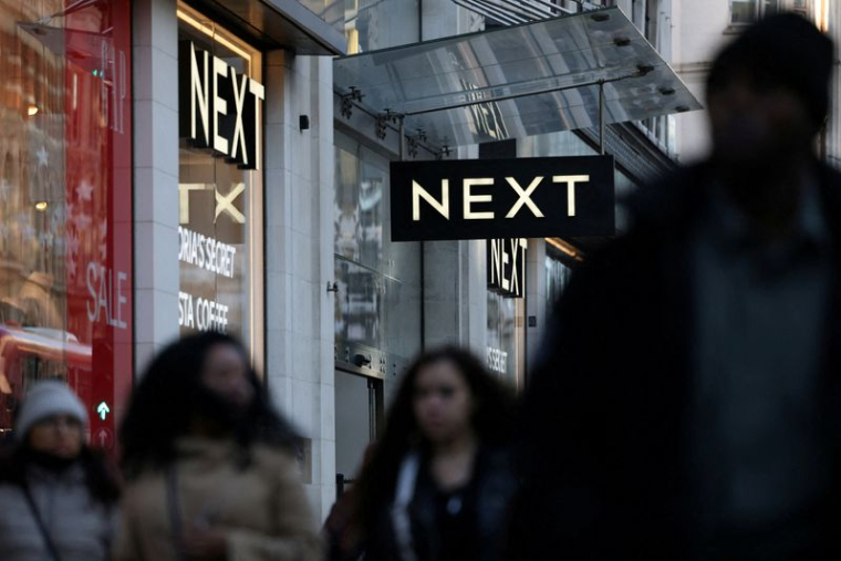 Des clients passent devant un magasin NEXT à Londres