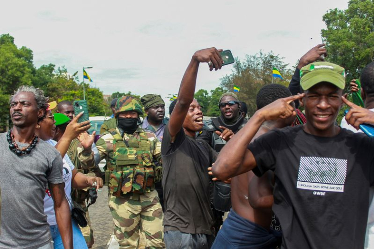 Des gens à Libreville, au Gabon, posent avec des soldats pour célébrer le coup d'État militaire