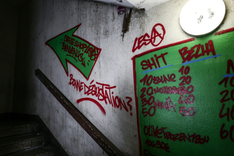 Des tarifs de stupéfiants peints sur le mur d'une cage d'escalier de la Cité des Oliviers à Marseille, le 9 décembre 2025  ( AFP / Thibaud MORITZ )