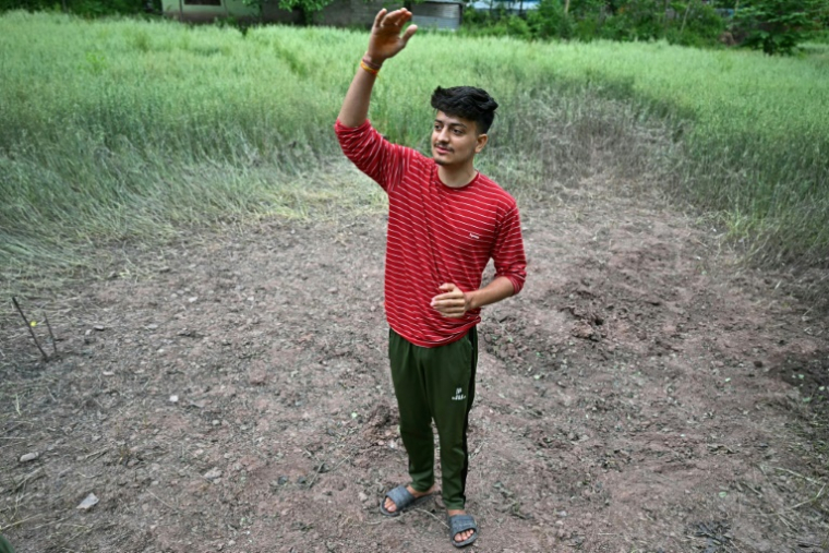 Badal, un étudiant indien, montre le cratère causé par un obus de mortier pakistanais près de sa maison à Uri, à 100 km de Srinagar, le 8 mai 2025 ( AFP / Sajjad HUSSAIN )