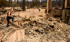 Kimber Renz regarde les ruines de sa maison détruite par les flammes à Spokane, dans l'Etat de Washington, le 4 août 2026 ( AFP / Josh Edelson )