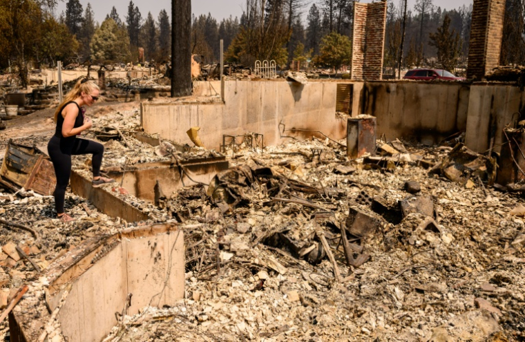 Kimber Renz regarde les ruines de sa maison détruite par les flammes à Spokane, dans l'Etat de Washington, le 4 août 2026 ( AFP / Josh Edelson )