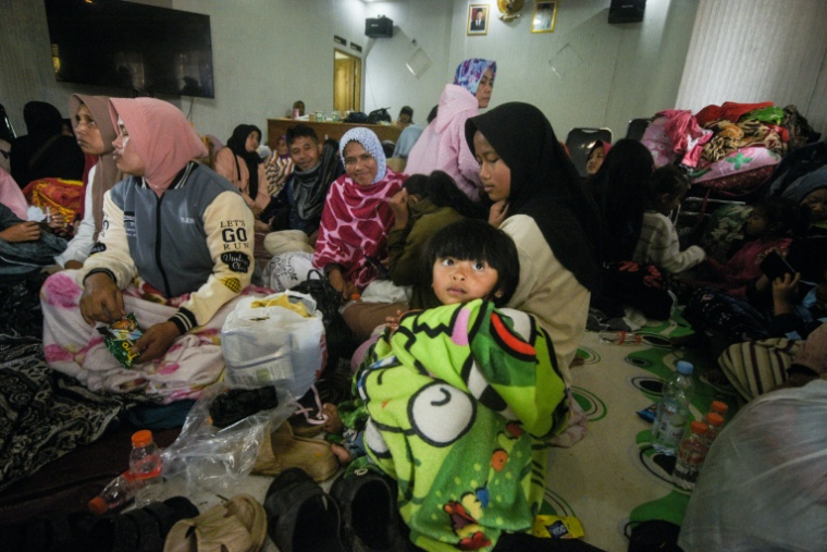 Des sinistrés évacués après un glissement de terrain dans le village de Pasirlangu, dans la région du Bandung occidental, au sud-est de Jakarta, le 24 janvier 2026 ( AFP / Timur Matahari )