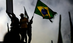 Un partisan du sénateur brésilien de droite et candidat à la présidence, Flavio Bolsonaro, agite un drapeau national lors d'un meeting de campagne à  Rio de Janeiro, le 3 octobre 2026 ( AFP / Douglas SHINEIDR )