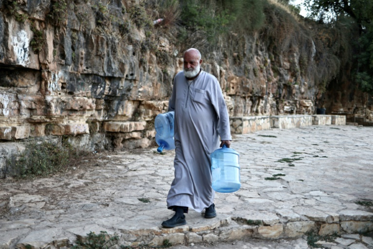Un Palestinien va chercher de l'eau à une source dans le village de Dura al-Qaraa, en Cisjordanie occupée, le 15 juillet 2025 ( AFP / Zain JAAFAR )