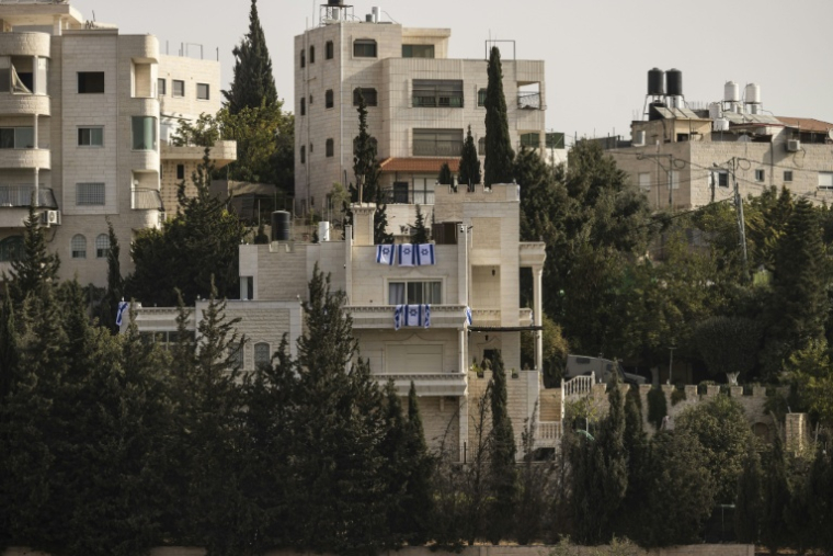 Des drapeaux israéliens placés sur des balcons après que l'armée israélienne a forcé des Palestiniens à évacuer le quartier d'Ein Deir Baha, dans la ville d'Hébron, en Cisjordanie occupée, le 24 octobre 2026  ( AFP / JOHN WESSELS  )