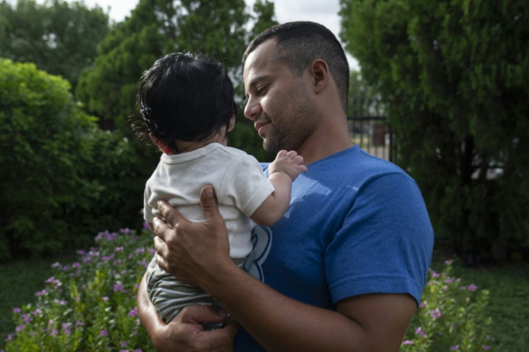 José Contreras, 30 ans, portant son fils de quatre mois à Edinburg au Texas, le 10 juillet 2026 ( AFP / Gabriel V. Cardenas )