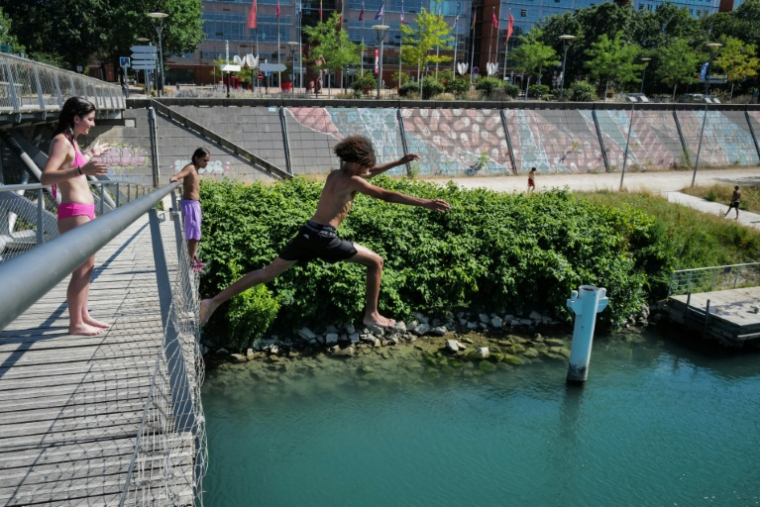 Un groupe d'adolescents saute  dans le Rhône depuis la Passerelle de la Paix à Lyon, le 25 juin 2026 ( AFP / OLIVIER CHASSIGNOLE )