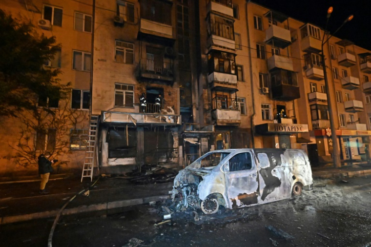 Des secouristes ukrainiens interviennent sur un immeuble résidentiel après une attaque de drones à Kharkiv dans la nuit du 2 au 3 mai 2025 ( AFP / SERGEY BOBOK )