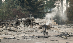 Une moto calcinée gît dans les ruines fumantes d'une habitation de Spokane (Etats-Unis) le 2 août 2026 ( AFP / Erick Doxey )