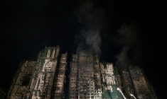 Les tours fumantes du complexe résidentiel Wang Fuk Court où un incendie s'est déclaré la veille, le 27 novembre 2025 à Hong Kong ( AFP / Philip FONG )