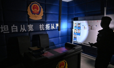 Le 12 mars 2026, un officier de l'armée royale thaïlandaise éclaire une pièce transformée en commissariat de police chinois, à l'intérieur d'un centre d'escroquerie abandonné à O'Smach, ville frontalière entre la Thaïlande et le Cambodge ( AFP / Lillian SUWANRUMPHA )