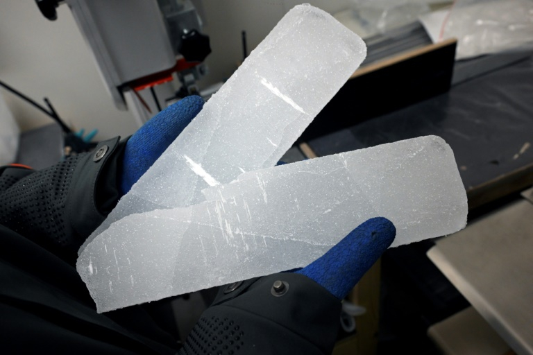 Un scientifique manipule des carottes glaciaires antarctiques dans un laboratoire à Bruxelles, le 15 juillet 2025 en Belgique ( AFP / Nicolas TUCAT )