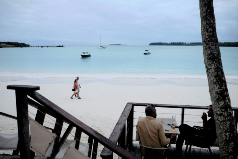 Un couple de touristes sur une plage de la baie de Kuto, sur l'île des Pins, en Nouvelle-Calédonie, le 18 mai 2021 ( AFP / Theo Rouby )